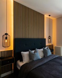 a bedroom with a bed, nightstand and lamp in front of a wall that has vertical stripes on it