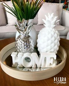 two pineapples are sitting on a tray with the word home