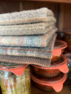 stack of towels sitting on top of each other next to glass jars filled with food