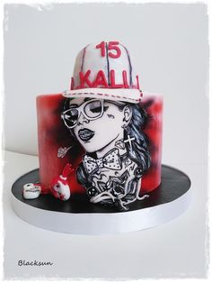 a red and white cake with a woman's face painted on the side, wearing a fireman hat