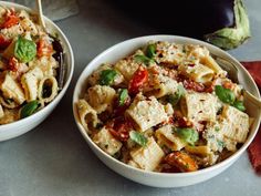 two white bowls filled with pasta and vegetables