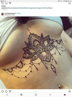 the back of a woman's stomach with an intricate tattoo design on her side