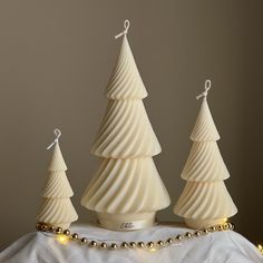 three white ceramic christmas trees on a table