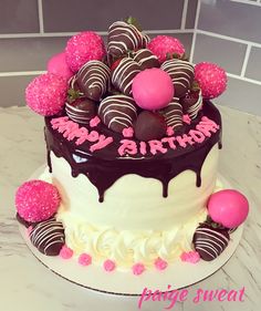 a birthday cake decorated with chocolate covered strawberries