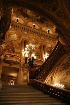 an ornate staircase with chandeliers in a building