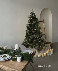 a table set for christmas with candles and a tree