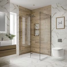 a bathroom with a toilet, sink and shower stall in white marbled wood - paneled walls