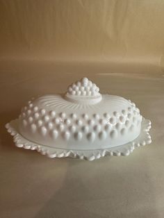 a white cake dish sitting on top of a table