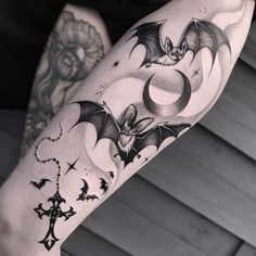 a woman's leg with tattoos on her legs and a bat flying through the air