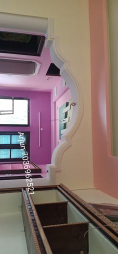 a mirror reflecting the inside of a room with pink walls and white trimmings