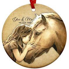 a round ornament with a horse and a woman kissing it's face