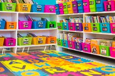 a room filled with lots of colorful bins and bookshelves on the wall