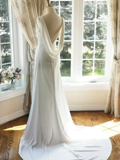 a wedding dress on display in front of a window