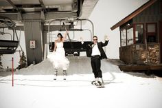 a man and woman in tuxedos standing on skis near a ski lift