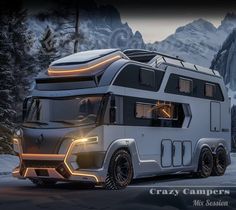 an rv is parked in the snow with mountains in the back ground and lights on