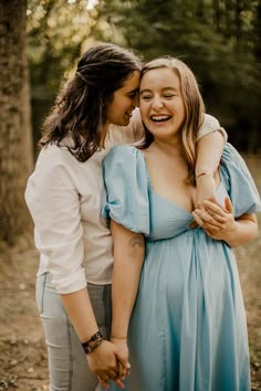 two women hugging each other in the woods