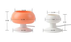 an orange and white lamp sitting next to each other on top of a white table