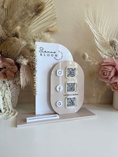 a white clock sitting on top of a table next to flowers