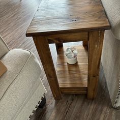 a small wooden table sitting on top of a hard wood floor next to a couch