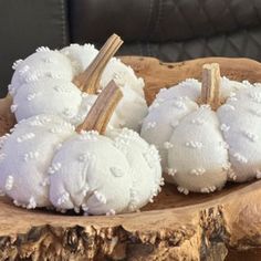 three white pumpkins sitting on top of a wooden tray