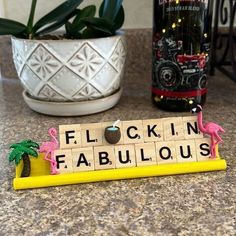 a scrabble tile sign that says flock in fabulous with pink flamingos on it