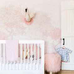 a baby's room with pink and white decor