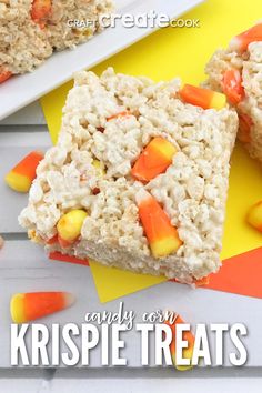 two pieces of rice krispie treats sitting on top of yellow and orange paper with candy corn