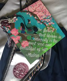 a decorated graduation cap on top of a white sheet with writing that reads, the flower that blossoms in adversity is the most sore and beautiful of any mulan