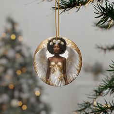 an ornament hanging from a christmas tree decorated with gold and white angel wings