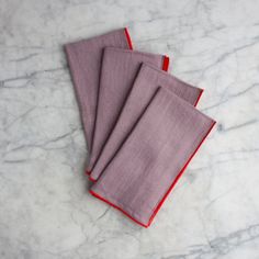 three red napkins sitting on top of a marble counter