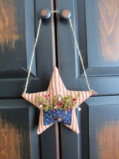 a red white and blue star hanging on a door handle with flowers in the center