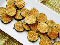 a white plate topped with sliced zucchini on top of a table