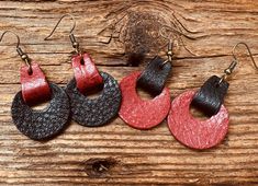 three pairs of leather earrings on wooden background