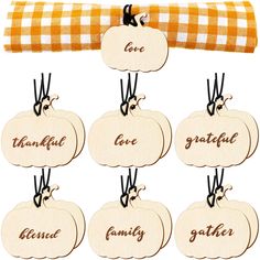 wooden pumpkins with the names of each family hanging from a checkered fabric ribbon