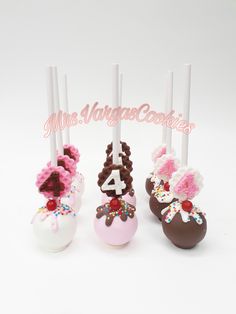 three chocolate covered cake pops with flowers on them