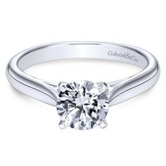 a white gold engagement ring with a round brilliant diamond in the center, on a plain band