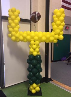 a balloon column with footballs and balloons in the shape of a cross on it