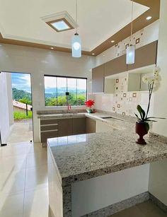 a kitchen with marble counter tops and an island in front of a large glass window