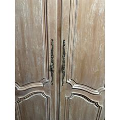 an old wooden door with ornate handles and knobs on the doors are painted white