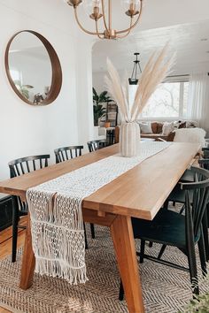 a dining room table with chairs and a vase on it