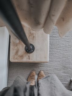 someone is standing on the floor with their feet up in front of a door handle