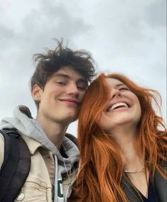 a young man and woman are smiling at the camera with their heads close to each other