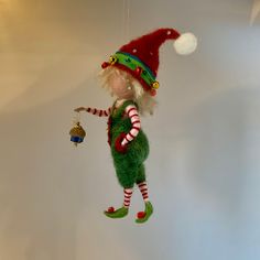 a christmas ornament hanging from the ceiling with a elf on it's head