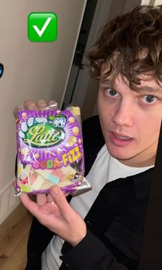 a young man holding up a bag of candy