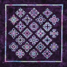 a purple and blue quilt with an intricate design on the front, in square shapes