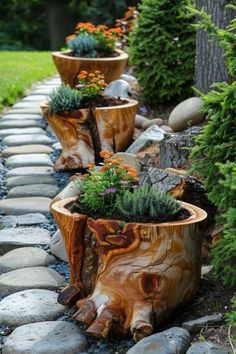 several wooden planters are lined up on the side of a stone path with flowers in them