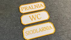 three yellow and white street signs sitting on top of a gray carpeted floor next to each other