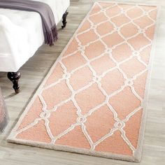 an orange and white rug on the floor in a bedroom