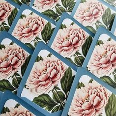 several square coasters with pink flowers and green leaves on blue background, arranged in rows