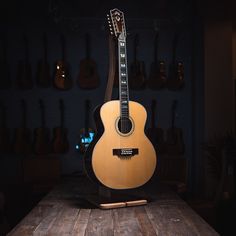 an acoustic guitar sits on top of a wooden table